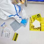 Cleanroom employee cleaning hazardous drug spill with spill kit and full PPE
